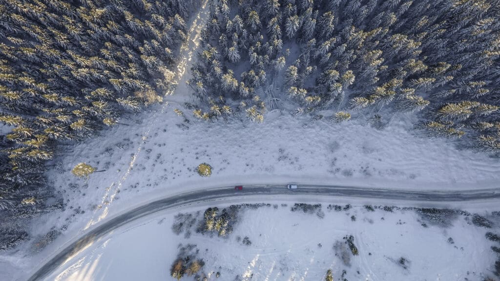 Aerial View of Windy Mountain Road with Snow and Cars holiday safe driving tips | Marietta Wrecker Service