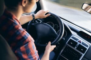 Young driver in his shirt in a nice modern car in motion | Marietta Wrecker Service