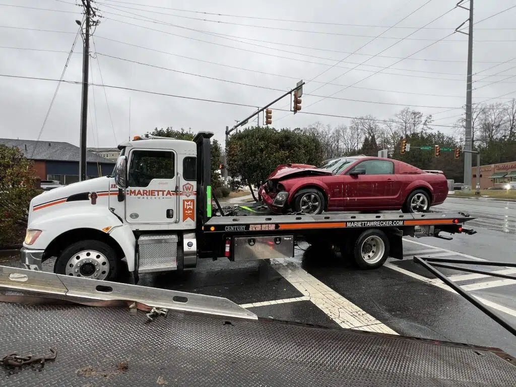 Tow truck carrying totaled red car | Marietta Wrecker, Need a Tow Soon